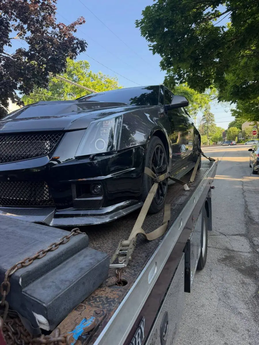 Cadillac on the deck towed by PS Towing & Recovery